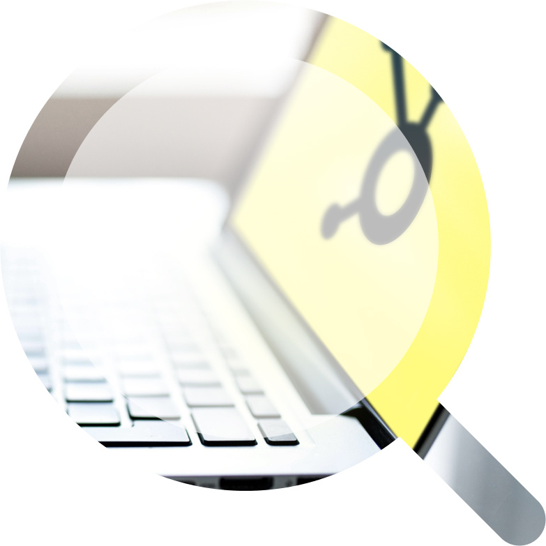 A magnifying glass overlay highlighting a laptop with a yellow screen displaying HubSpot logo